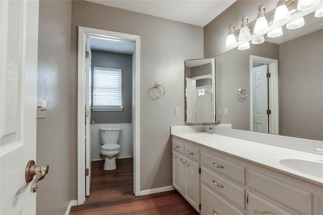 7205 N Seminole Ter, Warr Acres, OK 73132 - full bath with baseboards, double vanity, toilet, a sink, and wood finished floors
