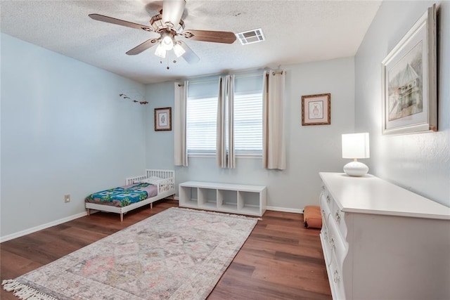 7205 N Seminole Ter, Warr Acres, OK 73132 - bedroom featuring visible vents, baseboards, a ceiling fan, a textured ceiling, and wood finished floors