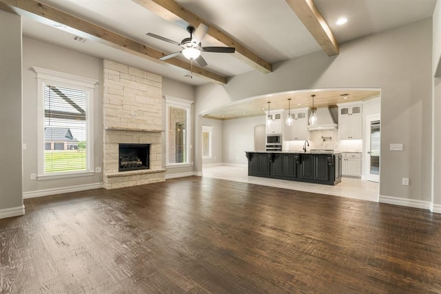4174 Richards Way, Piedmont, OK 73078 - unfurnished living room with a ceiling fan, beamed ceiling, light wood finished floors, a stone fireplace, and recessed lighting