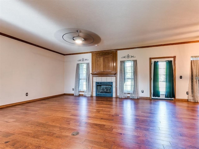 407 Heather Ln, Tuttle, OK 73089 - unfurnished living room featuring crown molding, wood finished floors, baseboards, and a fireplace
