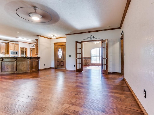407 Heather Ln, Tuttle, OK 73089 - unfurnished living room featuring ornamental molding, french doors, baseboards, and dark wood finished floors