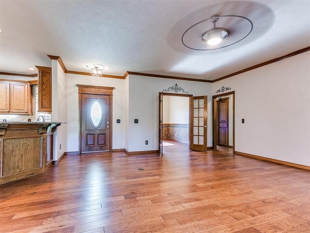 407 Heather Ln, Tuttle, OK 73089 - foyer entrance featuring light wood finished floors, baseboards, crown molding, and a textured ceiling