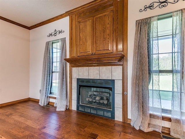 407 Heather Ln, Tuttle, OK 73089 - detailed view of a tile fireplace, crown molding, wood finished floors, and baseboards