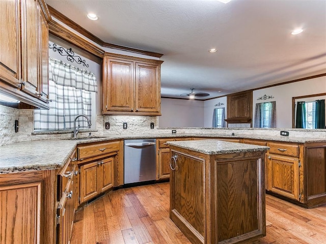 407 Heather Ln, Tuttle, OK 73089 - kitchen featuring stainless steel dishwasher, ornamental molding, a peninsula, a kitchen island, and brown cabinetry