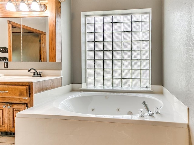 407 Heather Ln, Tuttle, OK 73089 - full bathroom with a tub with jets, a textured wall, and vanity
