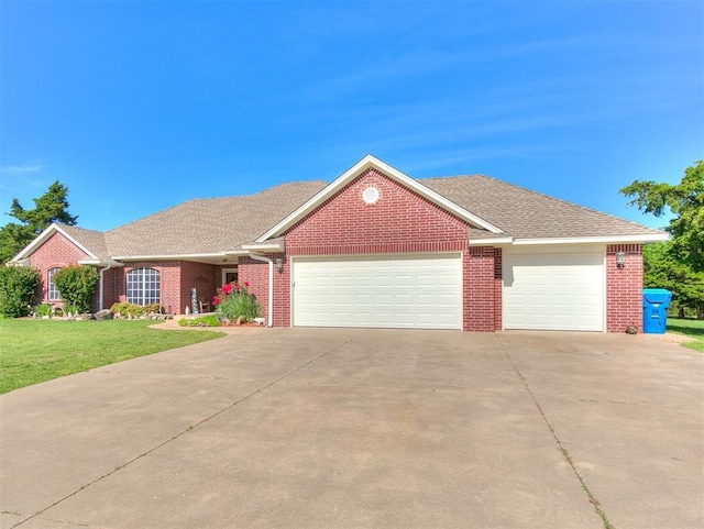 407 Heather Ln, Tuttle, OK 73089 - view of front of home with an attached garage, concrete driveway, a front yard, and brick siding