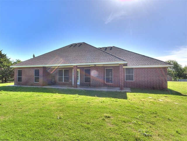 407 Heather Ln, Tuttle, OK 73089 - back of house with a patio, roof with shingles, a lawn, and brick siding