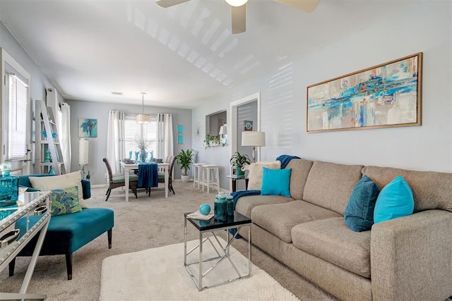 living room featuring baseboards, carpet flooring, ceiling fan, and visible vents