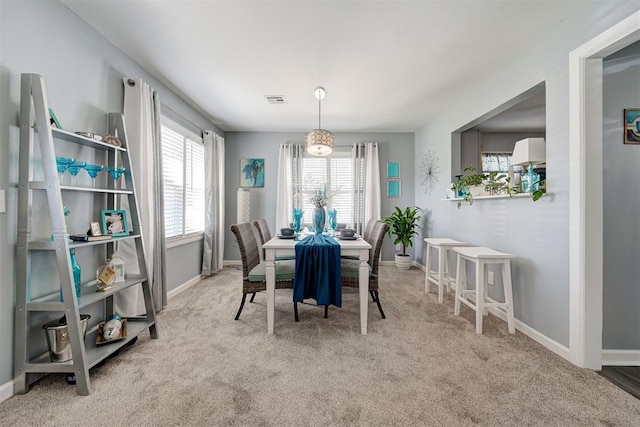 carpeted dining area featuring baseboards and visible vents