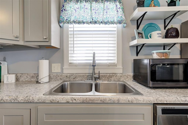 kitchen with a sink, light countertops, and appliances with stainless steel finishes