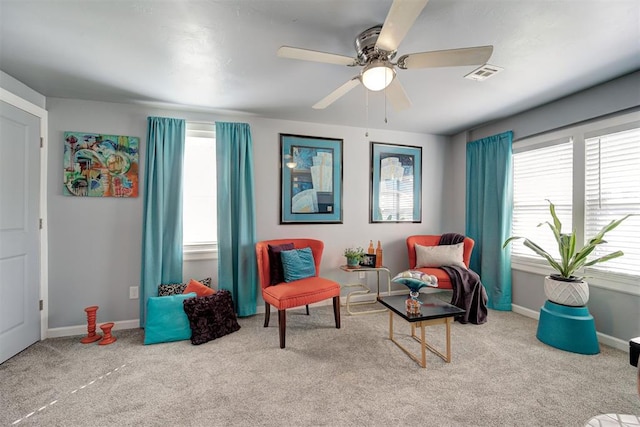 sitting room featuring visible vents, ceiling fan, carpet floors, and a healthy amount of sunlight