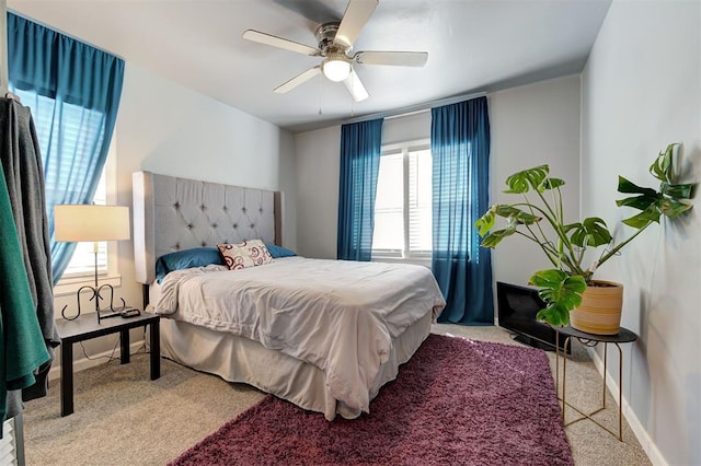 bedroom featuring carpet flooring, multiple windows, baseboards, and ceiling fan