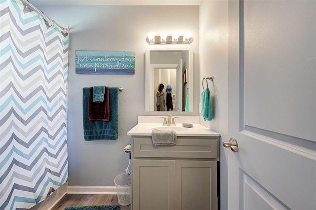bathroom featuring vanity, baseboards, a shower with curtain, and wood finished floors