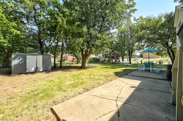 view of yard featuring a patio area, fence, an outdoor structure, and a shed
