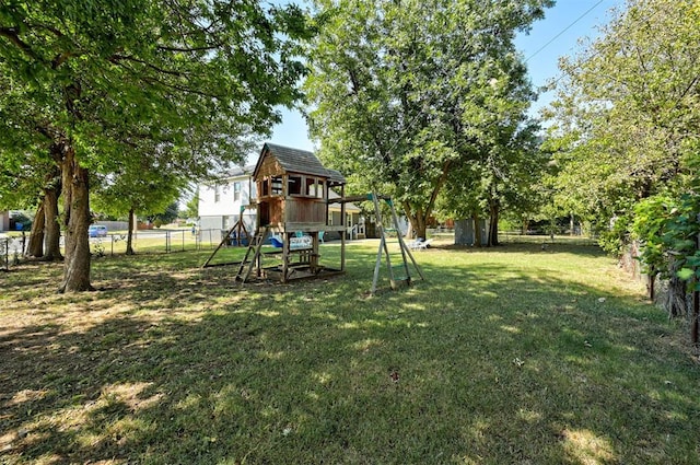 view of playground with fence and a lawn