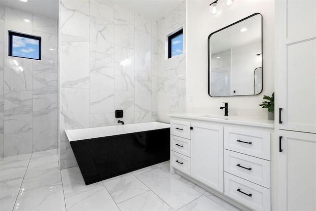 2109 Wiregrass Rd, Edmond, OK 73025 - full bath featuring marble look tile flooring, a soaking tub, and vanity