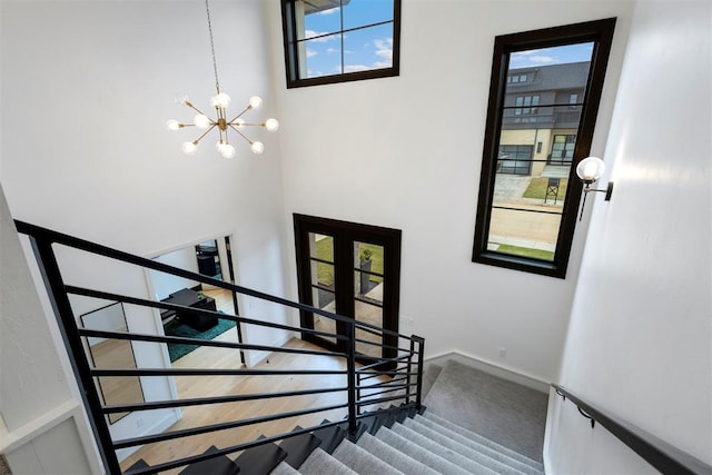 2109 Wiregrass Rd, Edmond, OK 73025 - stairs with a chandelier, a high ceiling, and carpet flooring