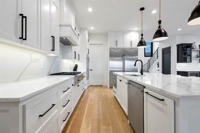 2109 Wiregrass Rd, Edmond, OK 73025 - kitchen with appliances with stainless steel finishes, light stone counters, light wood-type flooring, a spacious island, and recessed lighting