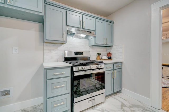 2765 NW 20th St, Oklahoma City, OK 73107 - kitchen featuring light countertops, under cabinet range hood, stainless steel gas range oven, marble finish floor, and baseboards