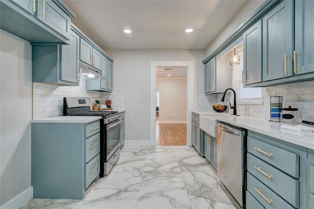 2765 NW 20th St, Oklahoma City, OK 73107 - kitchen with marble finish floor, light countertops, stainless steel appliances, and under cabinet range hood