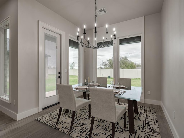 15216 Bedford Rd, Edmond, OK 73013 - dining room with baseboards, visible vents, wood finished floors, and an inviting chandelier