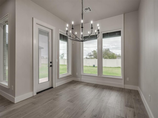 15216 Bedford Rd, Edmond, OK 73013 - unfurnished dining area featuring baseboards, visible vents, a notable chandelier, and wood finished floors