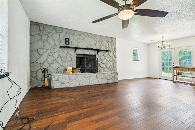 3206 Oakbriar Dr, Choctaw, OK 73020 - unfurnished living room featuring a textured ceiling, a ceiling fan, a chandelier, a stone fireplace, and wood finished floors