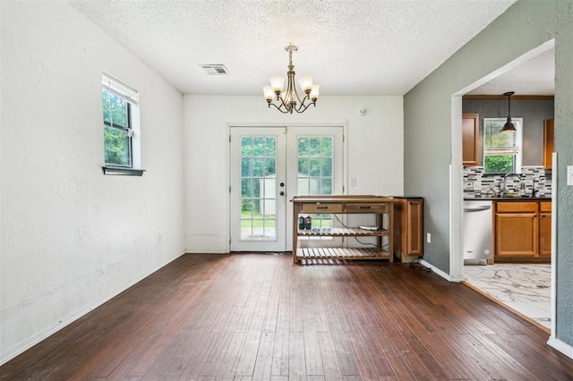 3206 Oakbriar Dr, Choctaw, OK 73020 - interior space featuring a chandelier, dark wood-style flooring, a textured ceiling, a sink, and french doors