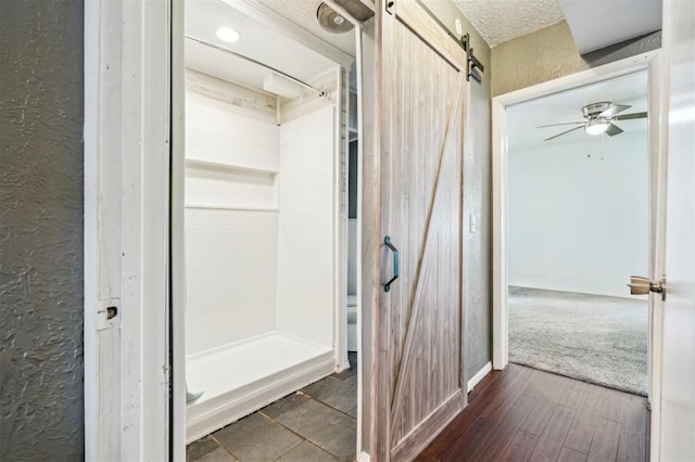 3206 Oakbriar Dr, Choctaw, OK 73020 - full bathroom with a textured wall, a shower stall, ceiling fan, wood finished floors, and a textured ceiling