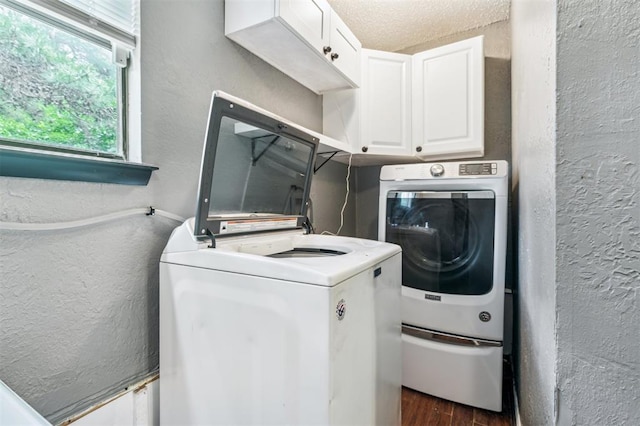 3206 Oakbriar Dr, Choctaw, OK 73020 - laundry area with separate washer and dryer, a textured wall, cabinet space, and dark wood-type flooring