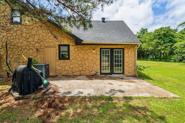 3206 Oakbriar Dr, Choctaw, OK 73020 - back of property featuring stone siding, a patio, central AC unit, a shingled roof, and a lawn