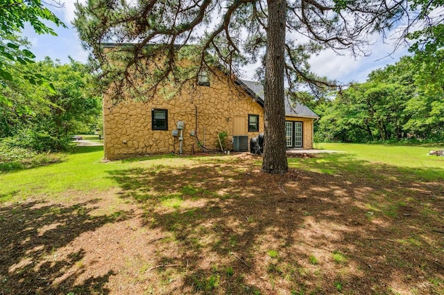 3206 Oakbriar Dr, Choctaw, OK 73020 - rear view of house featuring central AC, a yard, and stone siding