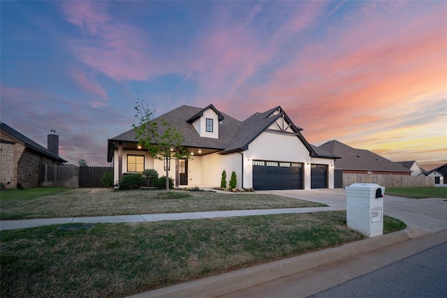 view of front of house featuring a garage, a yard, concrete driveway, and fence