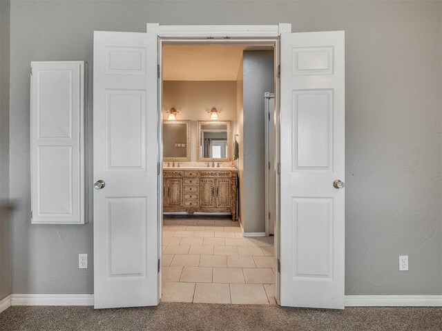 bathroom featuring tile patterned flooring, baseboards, and vanity