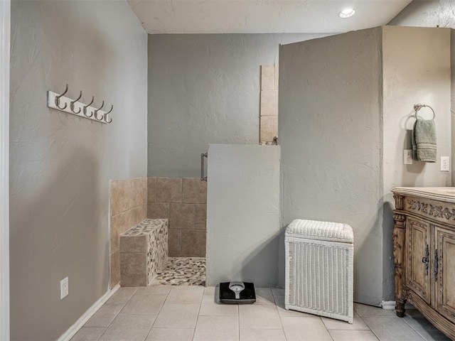 bathroom featuring a textured wall, tile patterned flooring, and vanity