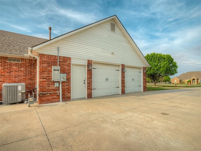 garage with driveway and central AC