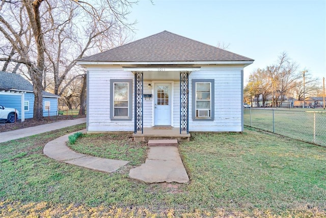 1011 W Mansur Ave, Guthrie, OK 73044 - view of front facade with cooling unit, a front yard, fence, and roof with shingles