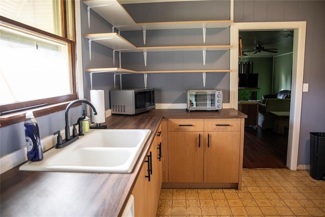 1011 W Mansur Ave, Guthrie, OK 73044 - kitchen with stainless steel microwave, light flooring, open shelves, a ceiling fan, and wood counters