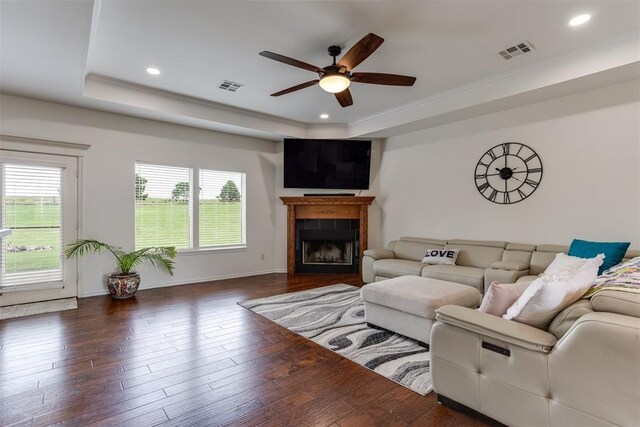 6574 Mint Julep Ln, Guthrie, OK 73044 - living area with a raised ceiling, a ceiling fan, a tile fireplace, wood finished floors, and ornamental molding