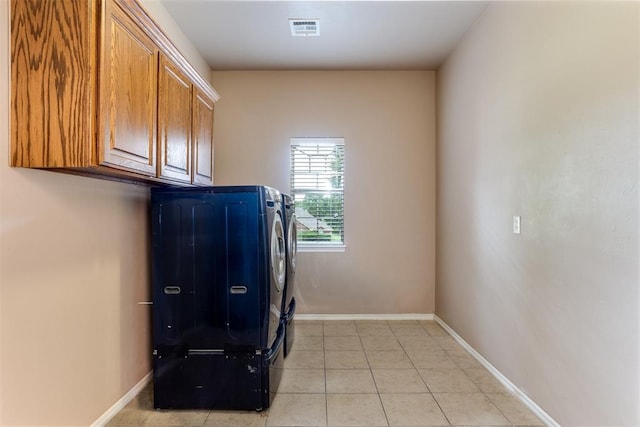 6574 Mint Julep Ln, Guthrie, OK 73044 - laundry room featuring independent washer and dryer, cabinet space, and light tile patterned flooring
