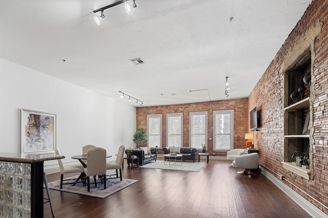 518 Colcord Dr, Oklahoma City, OK 73102 - living room with dark wood-style floors, visible vents, rail lighting, and brick wall