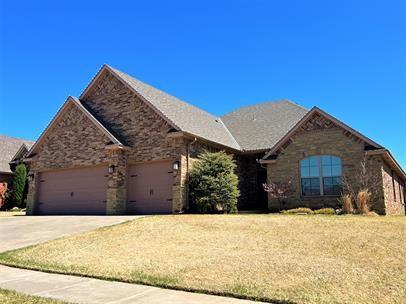 708 Kearny Ln, Yukon, OK 73099 - single story home with a garage, driveway, stone siding, and a front yard