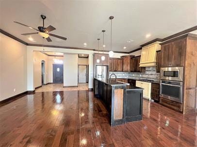 708 Kearny Ln, Yukon, OK 73099 - kitchen with appliances with stainless steel finishes, dark countertops, crown molding, dark wood-style floors, and custom exhaust hood