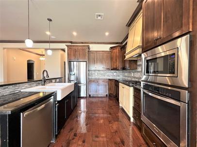 708 Kearny Ln, Yukon, OK 73099 - kitchen with appliances with stainless steel finishes, tasteful backsplash, pendant lighting, a kitchen island with sink, and recessed lighting