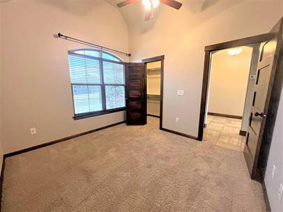 708 Kearny Ln, Yukon, OK 73099 - unfurnished bedroom featuring light colored carpet, a spacious closet, ceiling fan, a closet, and high vaulted ceiling