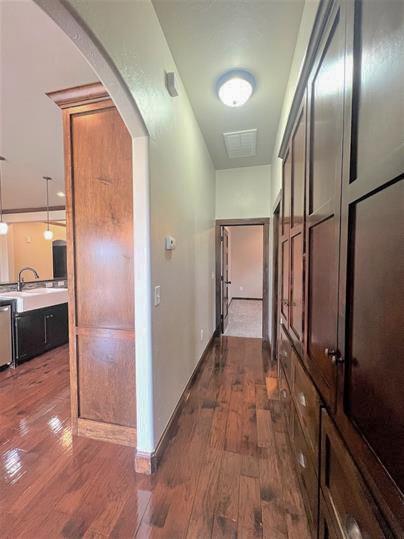 708 Kearny Ln, Yukon, OK 73099 - hallway with dark wood-style flooring and arched walkways