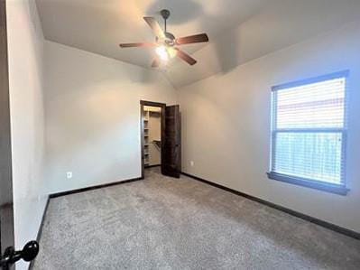 708 Kearny Ln, Yukon, OK 73099 - unfurnished bedroom featuring carpet, lofted ceiling, a walk in closet, and a ceiling fan