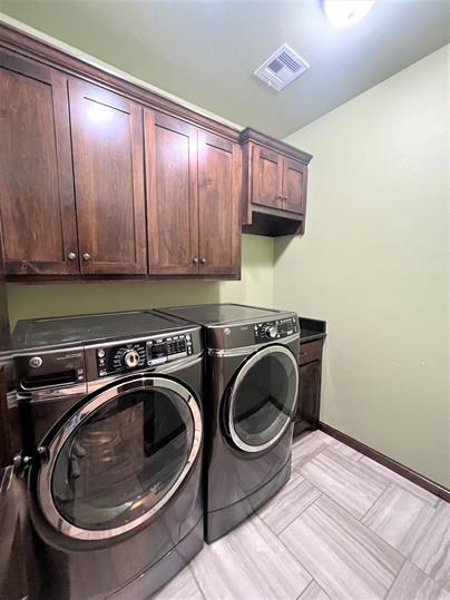 708 Kearny Ln, Yukon, OK 73099 - laundry area featuring cabinet space and washer and clothes dryer
