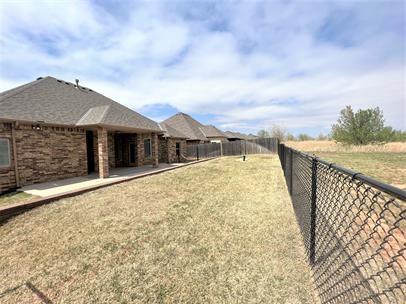 708 Kearny Ln, Yukon, OK 73099 - fenced backyard with a patio area