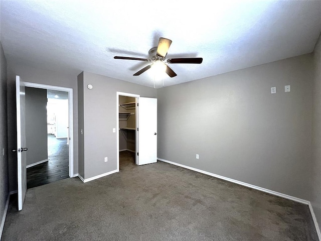 713 NW 143rd St, Edmond, OK 73013 - unfurnished bedroom featuring dark carpet, a walk in closet, ceiling fan, and a closet